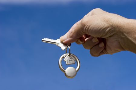 Woman holding a key for a house on a keychainの写真素材
