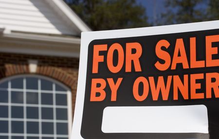 Home for sale - a sign in front of a brick house