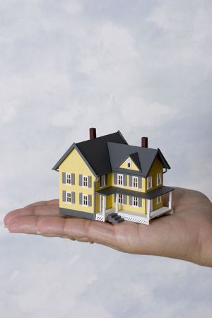 a woman holding a house in her hand with copy space fro your messageの写真素材