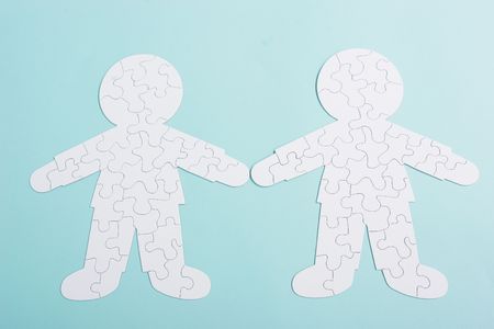 A puzzle in shape of a two human people - the puzzle of relationships - on blue backgroundの写真素材