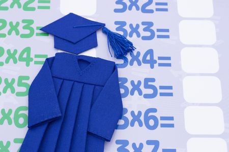 A blue graduation cap and gown on a multiplication table background