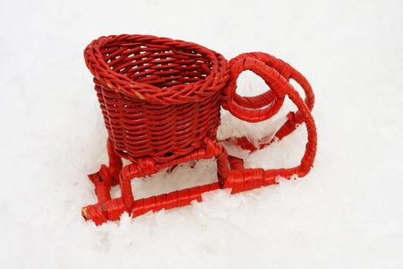 Red wicker sleigh on snowの写真素材