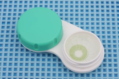 Colored Contact lens case on blue textured background
