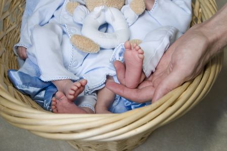 Baby feet with one being held up by daddyの写真素材