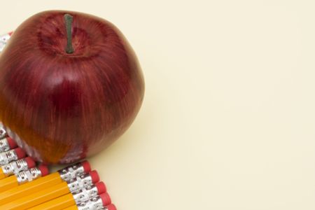 Pencils with an apple with copy spaceの写真素材