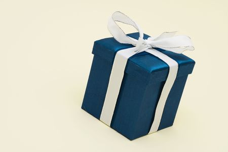 Blue gift on beige background with copy space