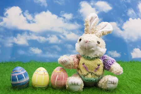 Easter bunny with eggs on grass with a sky background