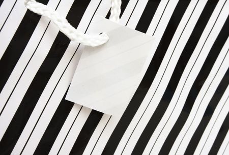 Black and white striped paper gift bag with empty tagの写真素材