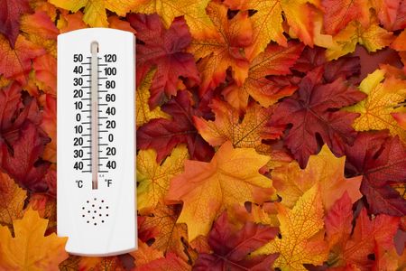 Thermometer on autumn leaves showing a cooling temperatureの写真素材