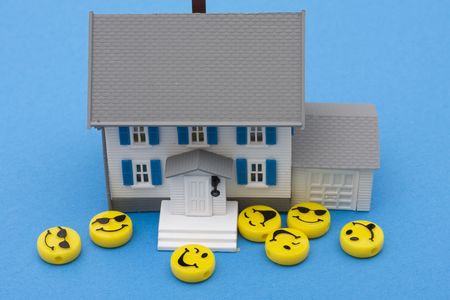 Smiley faces around a house on red background, friendly mortgage companyの写真素材