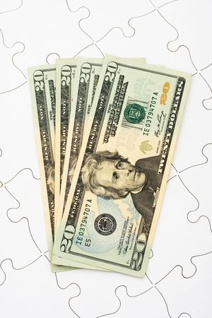 Puzzle with twenty dollar bills sitting on it. understanding finances