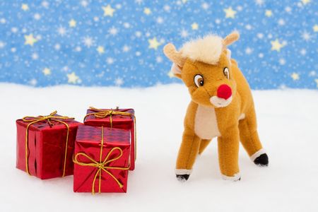 Reindeer in snow with presents on star background, merry Christmasの写真素材