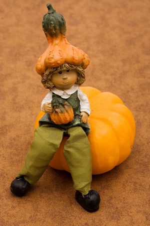 Boy sitting on pumpkin on brown background, pumpkinの写真素材