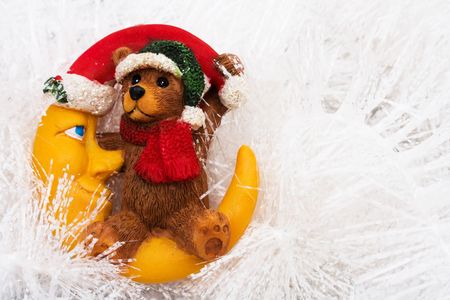 Teddy bear sitting on moon wearing Santa hat on white garland, Christmas nightの写真素材