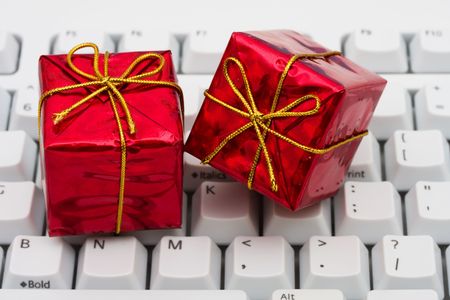 Red Christmas presents on grey computer keyboard, online Christmas shopping