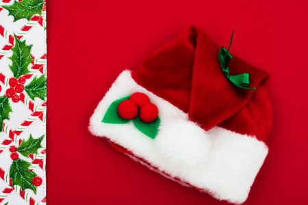 Candy cane, holly berries and leaf border with Santa hat on red background, Christmas borderの写真素材
