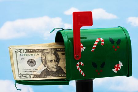 Green mailbox with twenty dollar bills on a blue sky backgroundの写真素材