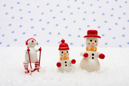 Snowman ornaments sitting on snow with a star background, Snowmenの写真素材