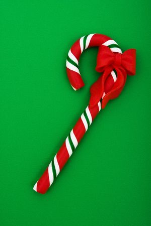 Candy cane with red ribbon on green background, Christmas backgroundの写真素材