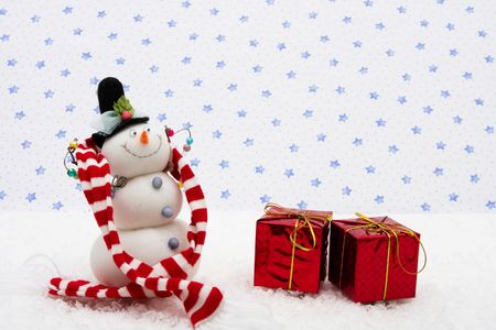 Snowman wearing scarf with red presents on star background, merry Christmas の写真素材