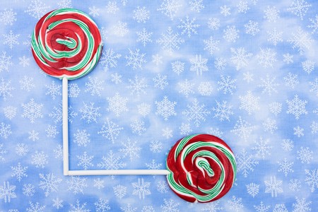 Colourful lollipops on blue snowflake background, lollipopの写真素材
