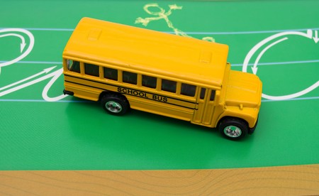 Yellow school bus sitting on green chalkboard background, school busの写真素材