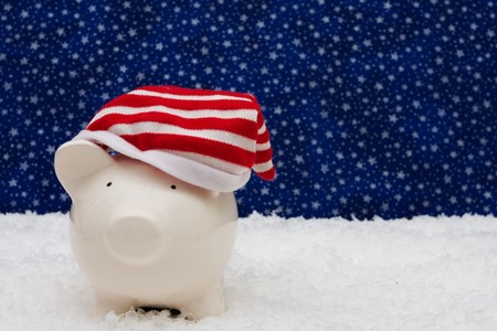 Piggy bank wearing Christmas stocking cap sitting on snow with star background, Christmas savingsの写真素材
