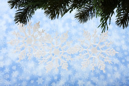 Snowflakes hanging from a tree on snowflake backgroundの写真素材