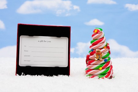 Candy Christmas tree sitting with gift card on sky background, gift cardの写真素材