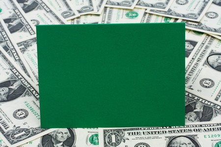 Green blank card sitting on one dollar bill background, money issuesの写真素材