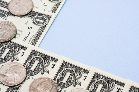 One dollar bills and coins sitting on a blue background, dollar bill border