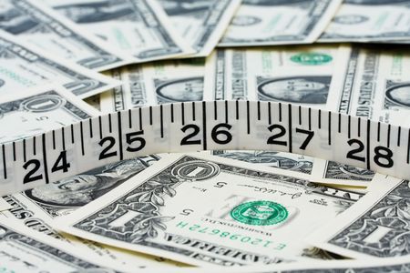 Measuring tape sitting on one dollar bill background, Costs of weight lossの写真素材