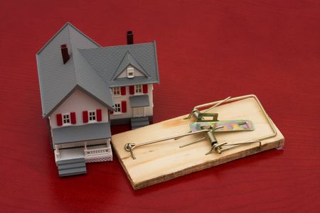 A mouse trap beside a house on red background, mortgage trapの写真素材