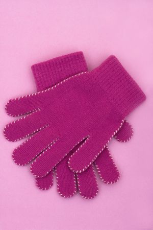 A pair of purple gloves sitting on a purple background, winter time の写真素材