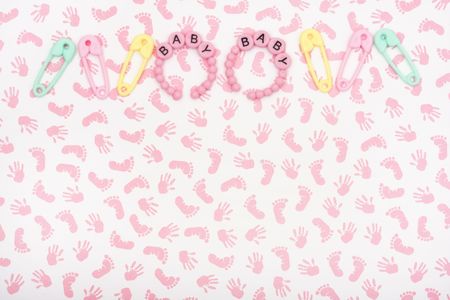 A pink baby pacifier with diaper pins on a calendar background, baby due dateの写真素材