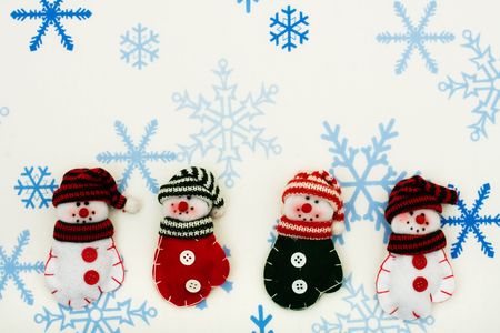 Four snowman  mittens sitting together on a snowflake background, happy holidaysの写真素材