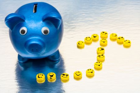 A blue piggy bank with smiley faces making an arrow on a shiny background, smile your savingの写真素材