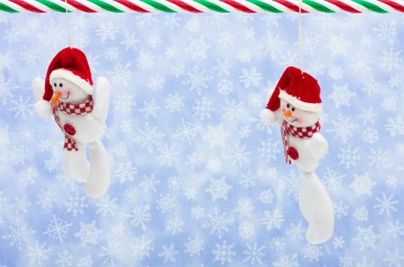 Snowman hanging on a snowflake background, Christmas backgroundの写真素材