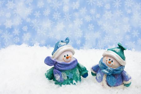 A snowman sitting on snow with a sky background, happy holidaysの写真素材