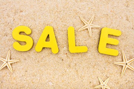 The word sale sitting on a beach with starfish, vacation moneyの写真素材