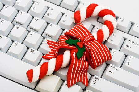 A candy cane sitting on computer keyboard, Christmas shopping onlineの写真素材
