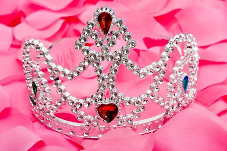 A princess tiara sitting on a pink flower petal background, princess tiaraの写真素材