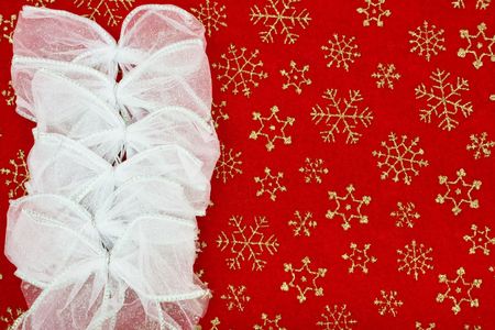 Silver bows making a border on a red snowflake background, Christmas bow border