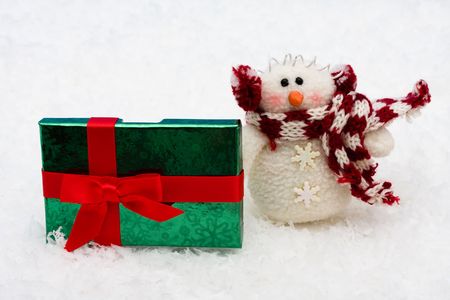 Christmas presents with a snowman sitting on snow background, Christmas Presentsの写真素材