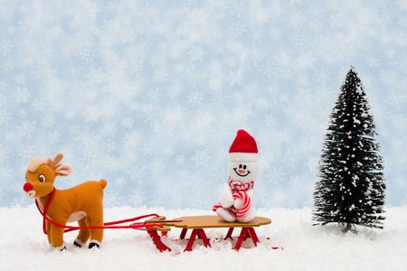 Evergreen trees sitting with a wooden sleigh with a blue snowflake background, Winter timeの写真素材