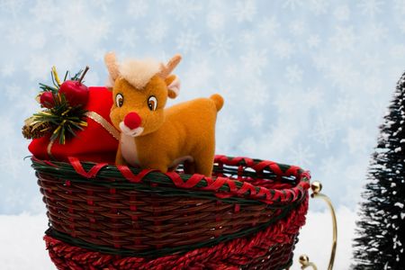 Evergreen trees sitting with a wicker sleigh with a blue snowflake background, Winter timeの写真素材