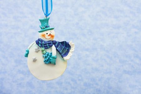 Snowmen ornaments hanging on a blue snowflake background, snowflake backgroundの写真素材