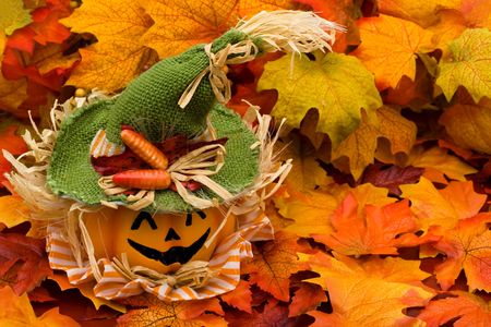 Fall leaves with a jack o lantern on a leaf backgroundの写真素材