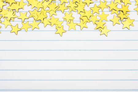 Gold stars making a border on a lined paper background, gold star borderの写真素材