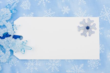 A blank gift tag on a blue snowflake backgroundの写真素材